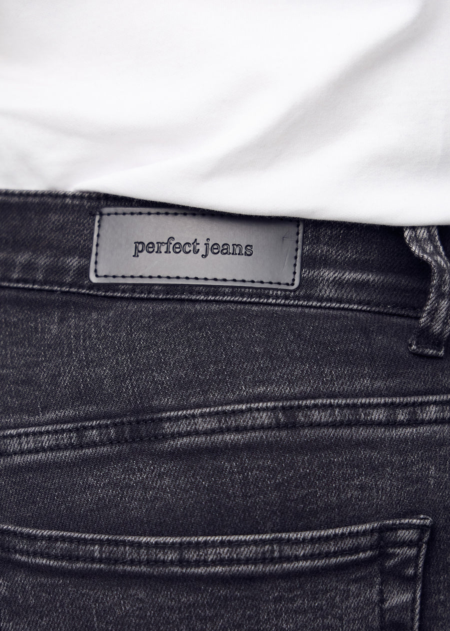 Närbild av mörkgrå denim med Perfect Jeans läderpatch bak i midjan på en plus-size modell.