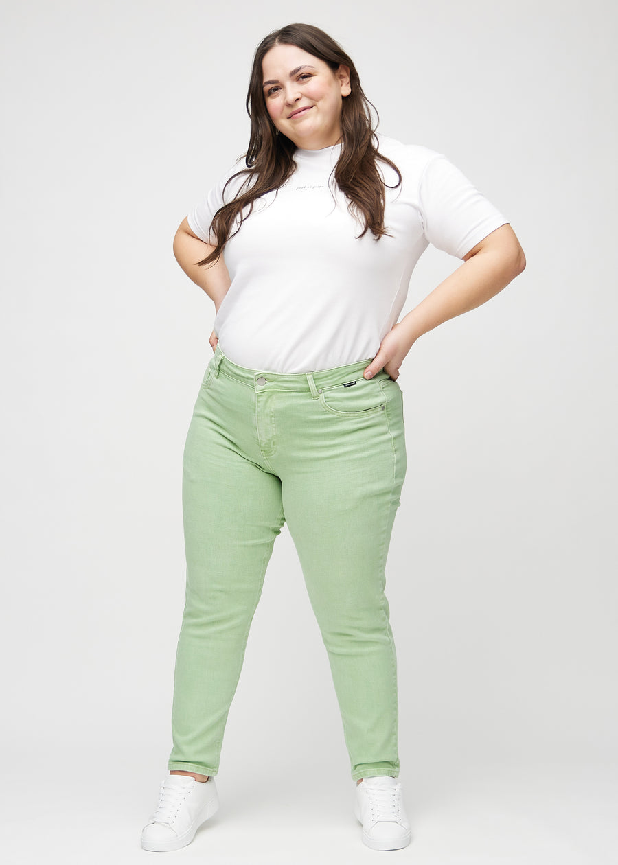 Plus-size model går ind i billedet, strækker i jeansene, viser dem frem ved at dreje rundt, og forlader derefter billedet.