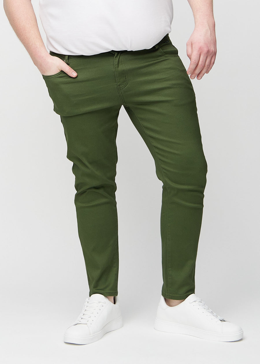 Mørkegrønne slim jeans, modelnavn Renewals, som sidder tæt til benet på en plus-size model, set forfra.