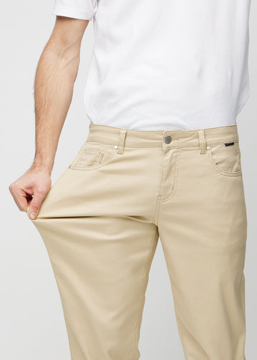 Model strækker jeansene ved låret for at vise stretch.