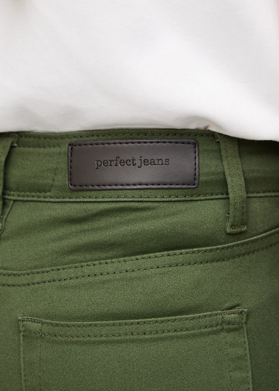 Nærbillede af grønt jeansmateriale med Perfect Jeans læderpatch bagpå i taljen.