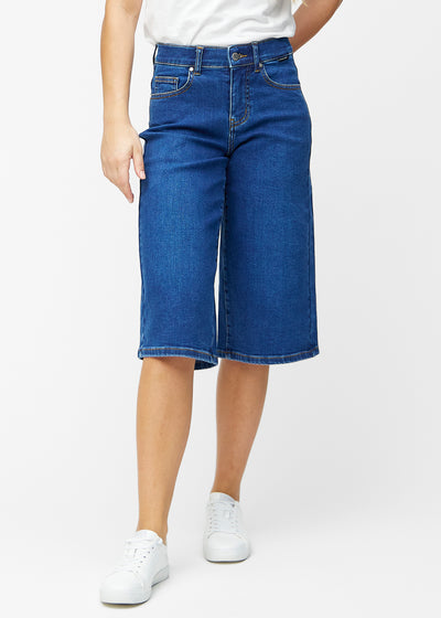 Løse, mørkeblå denim capris i farven Oceans, der sidder til ved hoften og falder løst ned over lårene til lige under knæet, set forfra.