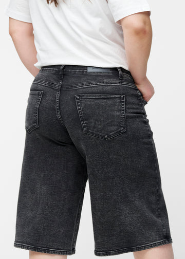 Løse, mørkegrå denim capris i farven Shadows set bagfra tæt på på plus-size model for at vise pasform og detaljer.