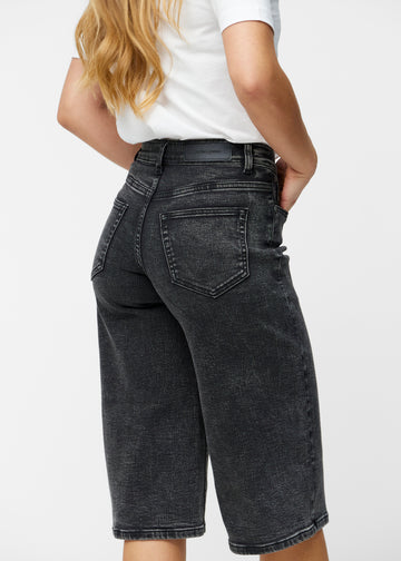 Løse, mørkegrå denim capris i farven Shadows set bagfra tæt på for at vise pasform og detaljer.