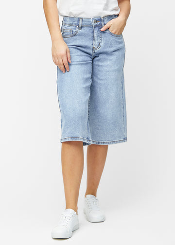 Lösa, ljusblå denim capris i färgen Waves som sitter vid höften och faller löst över låren till precis under knät, sett framifrån.