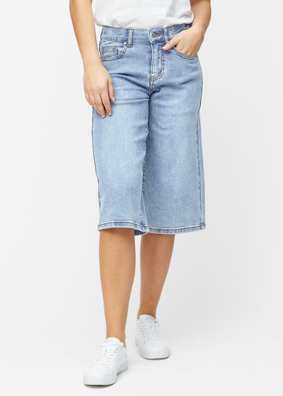 Lösa, ljusblå denim capris i färgen Waves som sitter vid höften och faller löst över låren till precis under knät, sett framifrån.