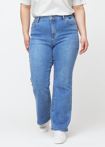 Blå mid-rise bootcutjeans i färgen Rivers. Framifrån på en plus size-modell, med nära passform över höfter och lår och lätt utsvängning nedtill.