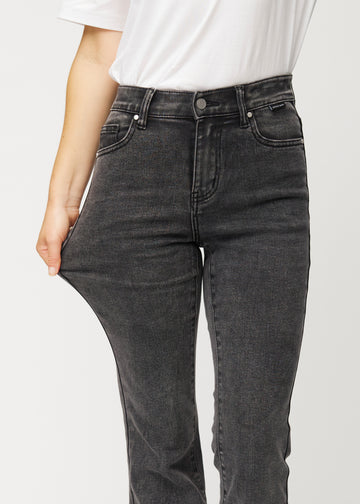 Mörkgrå mid-rise bootcutjeans i färgen Shadows. En modell drar i jeanstyget vid låret för att visa stretchen.