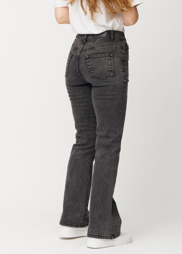 Mörkgrå mid-rise bootcutjeans i färgen Shadows. Bakifrån på en modell, så att hela passformen syns.