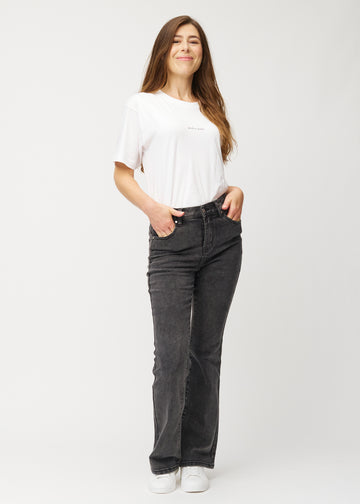 Mörkgrå mid-rise bootcutjeans i färgen Shadows. Helbild av en modell i jeansen.