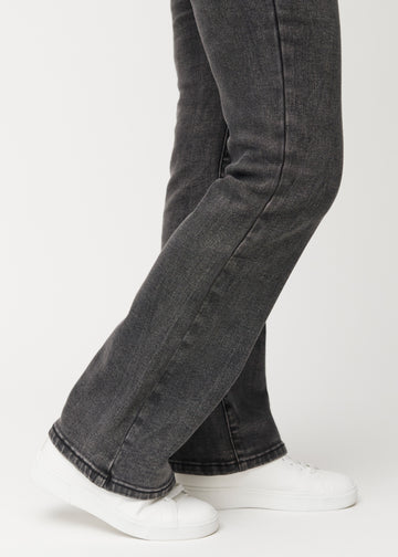 Mörkgrå mid-rise bootcutjeans i färgen Shadows. Närbild vid ankeln på en modell som visar den lätta utsvängningen nedtill.