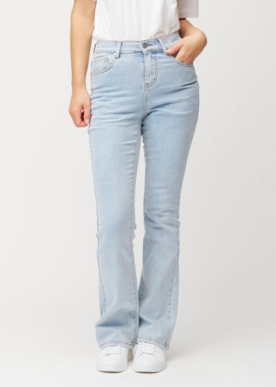 Ljusblå mid-rise bootcutjeans i färgen Waves. Framifrån på en modell, med nära passform över höfter och lår och lätt utsvängning nedtill.