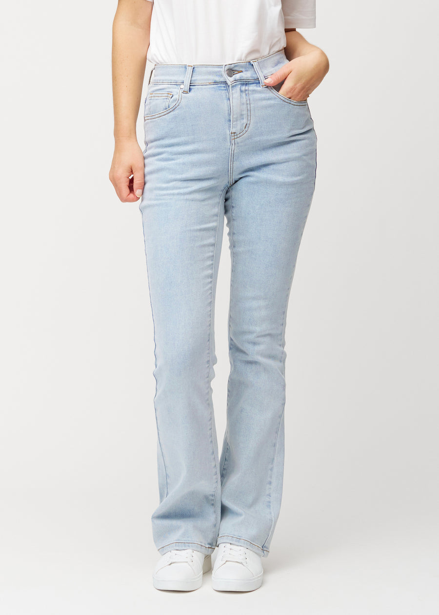 Ljusblå mid-rise bootcutjeans i färgen Waves. Framifrån på en modell, med nära passform över höfter och lår och lätt utsvängning nedtill.