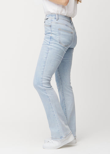 Ljusblå mid-rise bootcutjeans i färgen Waves. Från sidan på en modell.