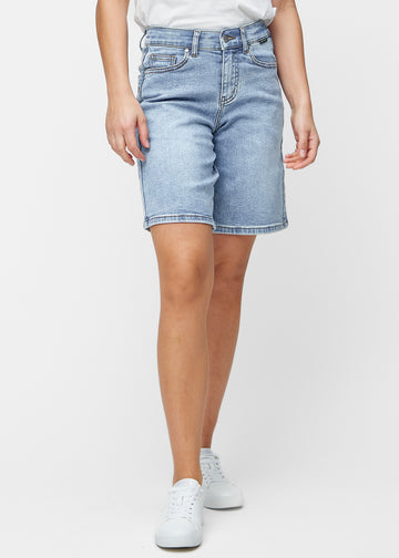 Lösa, ljusblå denimshorts i färgen Waves som sitter vid höften och faller löst över låren till precis över knät, sett framifrån.
