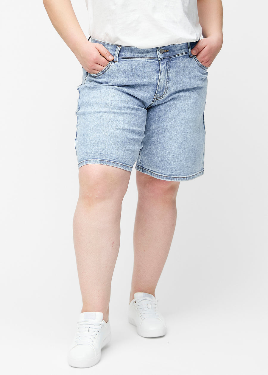 Lösa, ljusblå denimshorts i färgen Waves sedda framifrån på plus-size modell, som sitter vid höften och faller löst.