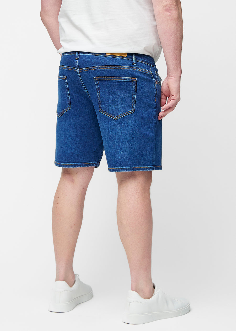 Mörkblå denimshorts för herr i färgen Oceans sett bakifrån på plus-size modell.