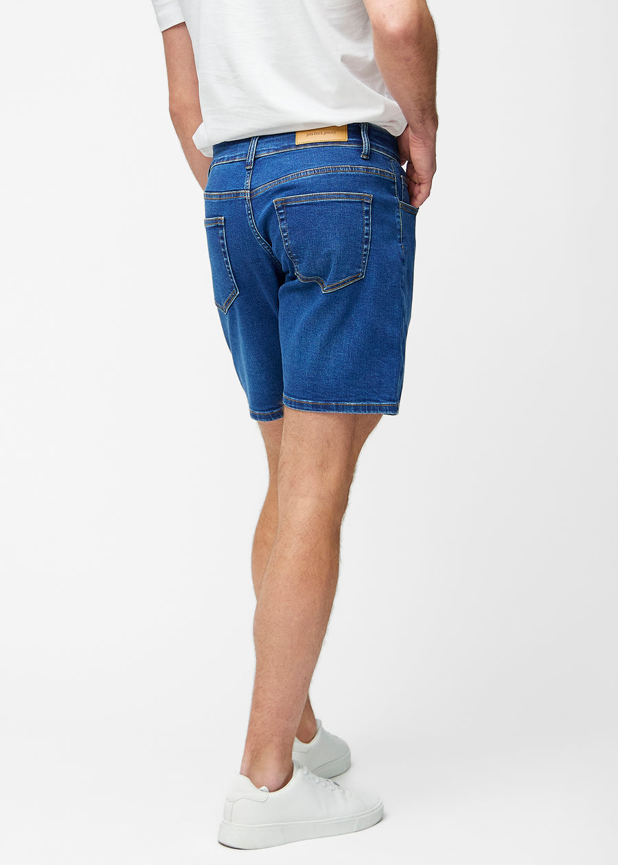 Mörkblå denimshorts för herr i färgen Oceans sett bakifrån så att längden till precis över knät och passformen kan ses.