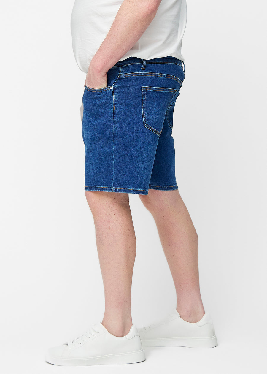 Mörkblå denimshorts för herr i färgen Oceans med regular passform sett från sidan på plus-size modell.