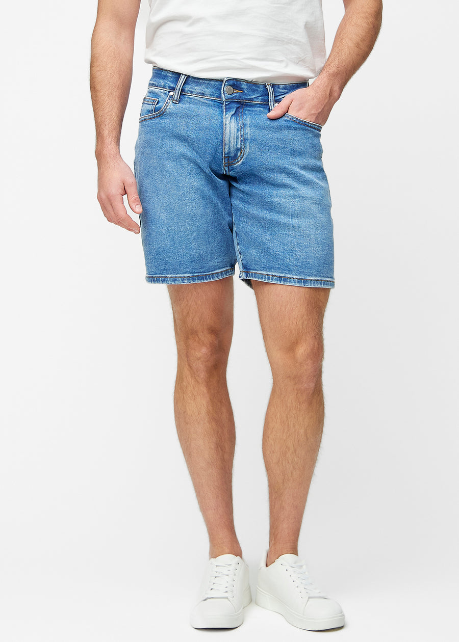 Blå denimshorts för herr i färgen Rivers med regular passform som sitter naturligt vid höften och ger luft runt låren, sett framifrån.