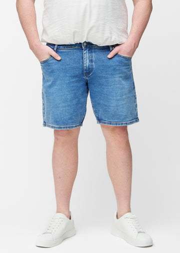 Blå denimshorts för herr i färgen Rivers med regular passform sett framifrån på plus-size modell som sitter naturligt vid höften och ger luft runt låren.
