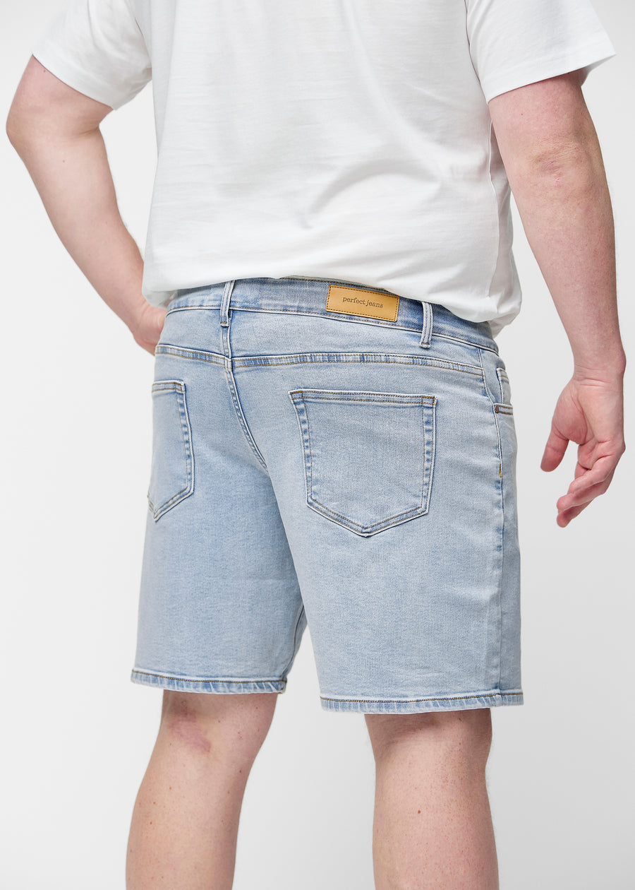 Ljusblå denimshorts för herr i färgen Waves sett bakifrån på nära håll på plus-size modell för att visa passform och detaljer.