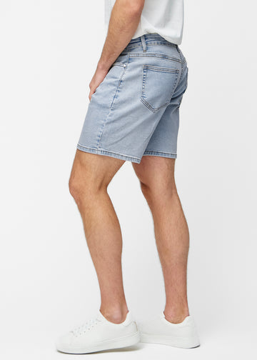 Ljusblå denimshorts för herr i färgen Waves med regular passform sett från sidan på modell.
