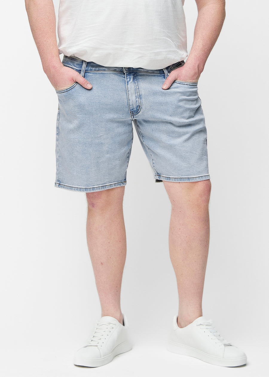 Ljusblå denimshorts för herr i färgen Waves med regular passform sett framifrån på plus-size modell, som sitter naturligt vid höften och ger luft runt låren.
