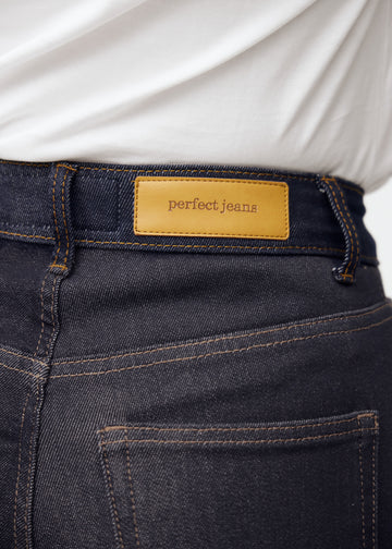 Närbild av mörkblå denim med Perfect Jeans läderpatch bak i midjan.