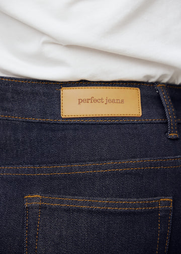 Närbild av mörkblå denim med Perfect Jeans läderpatch bak i midjan på plus-size modell.