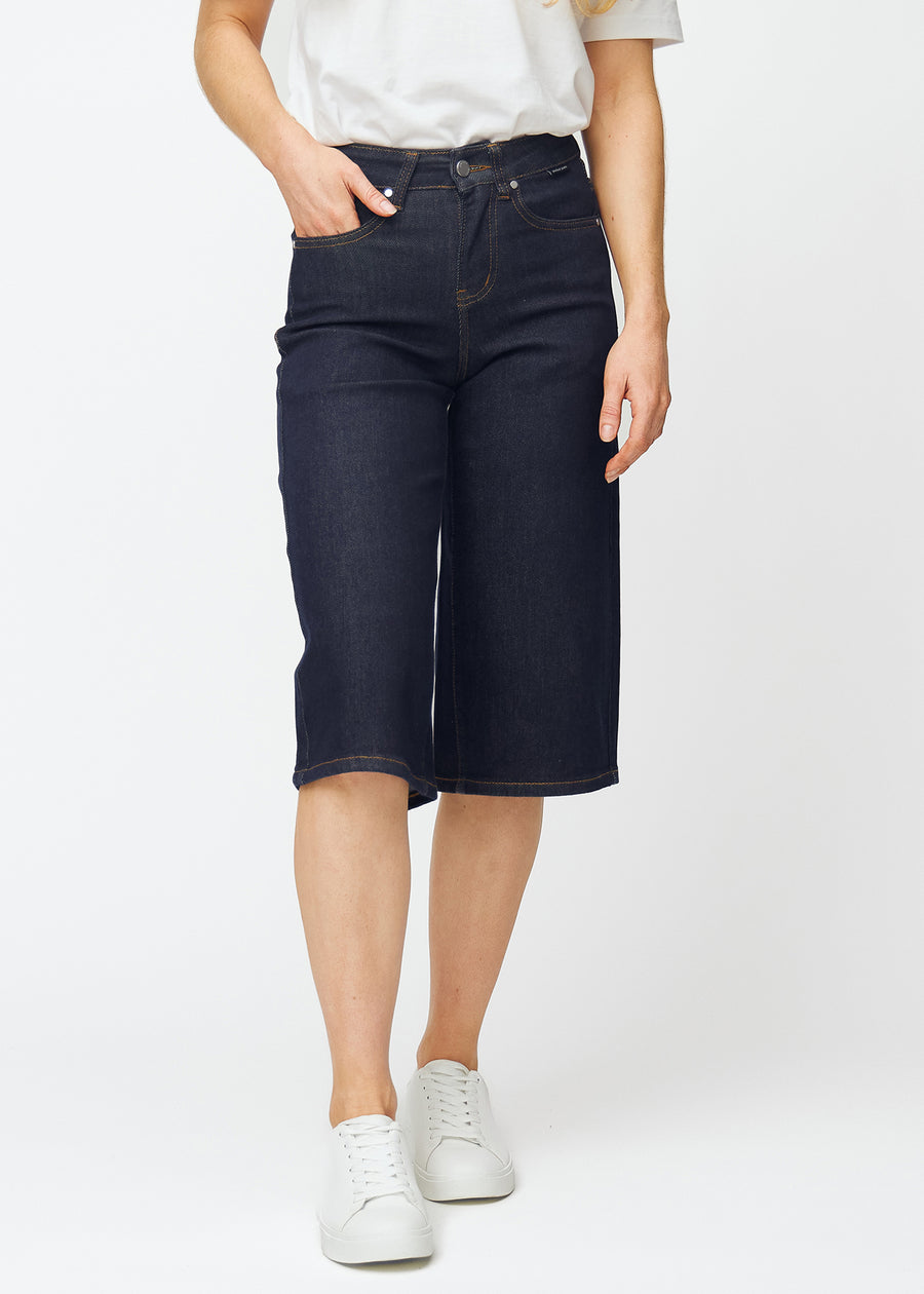 Mörkblå denim capris för dam i färgen Midnights med loose passform som sitter vid höften och faller löst över lår och ben, sett framifrån.