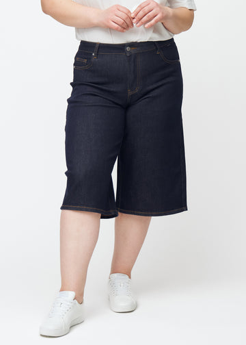 Mörkblå denim capris för dam i färgen Midnights med loose passform sett framifrån på plus-size modell.