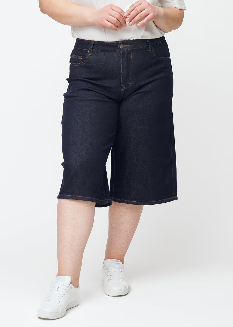 Mörkblå denim capris för dam i färgen Midnights med loose passform sett framifrån på plus-size modell.