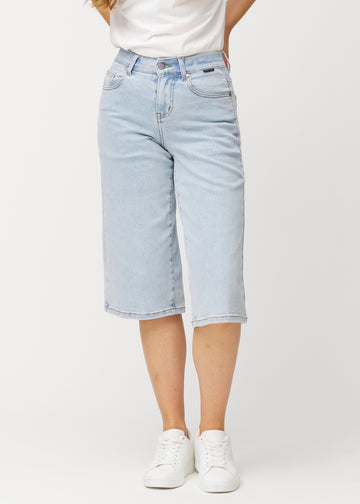 Lösa, ljusblå Waves denimcapribyxor som sitter åt vid höfterna och faller löst över låren till strax nedanför knät, sedda framifrån.