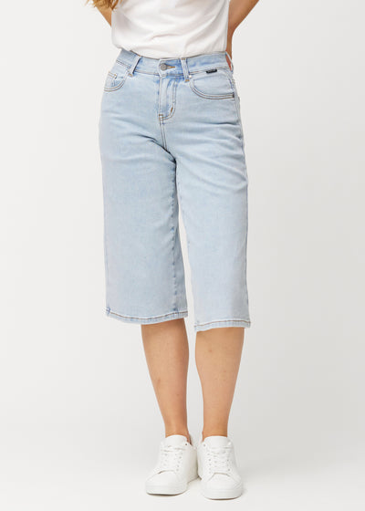 Lösa, ljusblå Waves denimcapribyxor som sitter åt vid höfterna och faller löst över låren till strax nedanför knät, sedda framifrån.