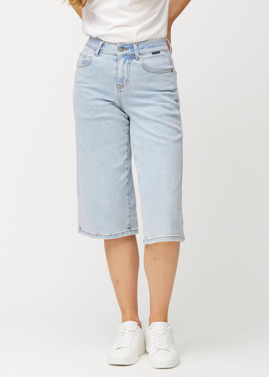 Lösa, ljusblå Waves denimcapribyxor som sitter åt vid höfterna och faller löst över låren till strax nedanför knät, sedda framifrån.