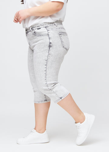 Ljusgrå denim regular capris sedda från sidan på en plus-size-modell.