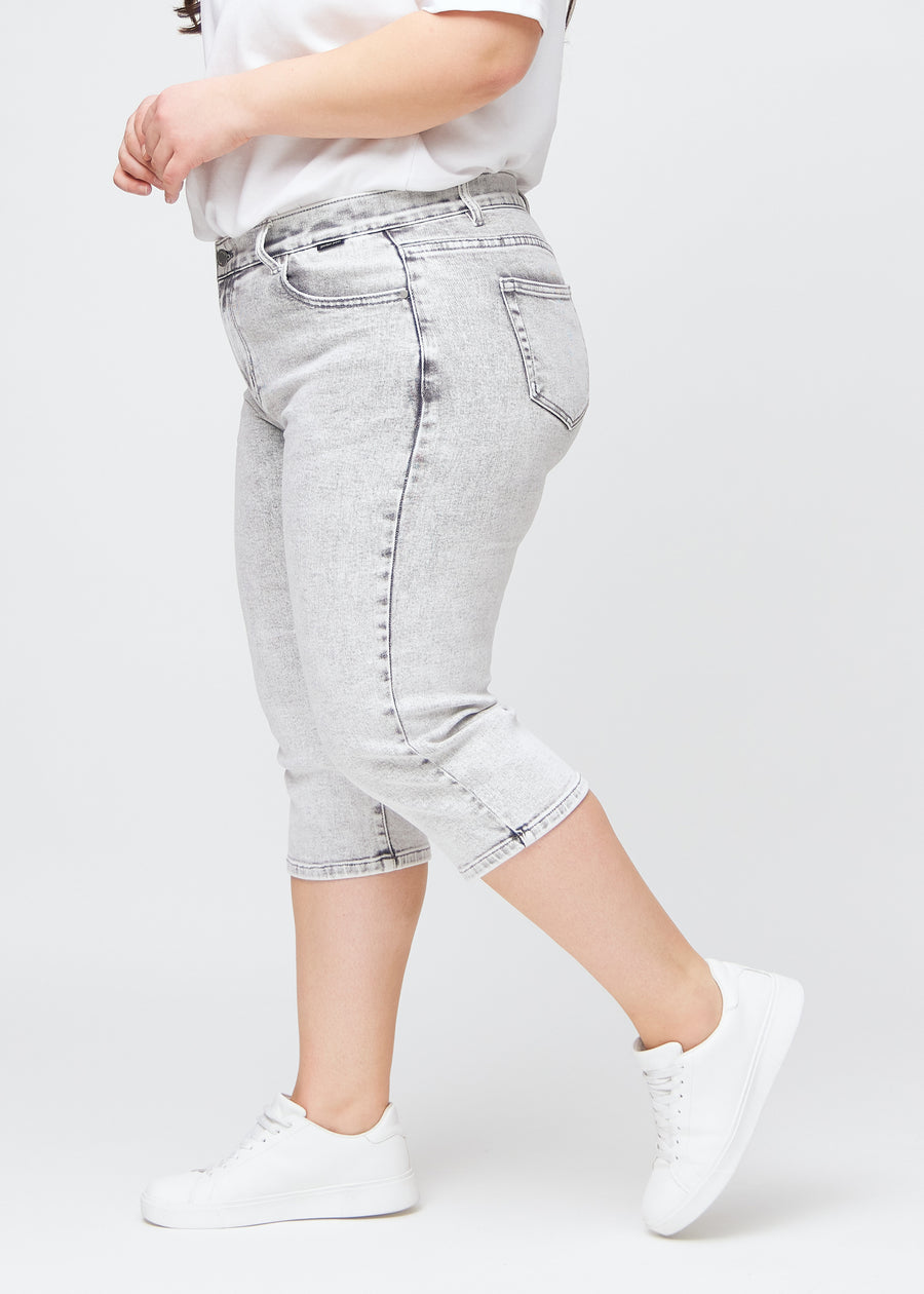 Ljusgrå denim regular capris sedda från sidan på en plus-size-modell.