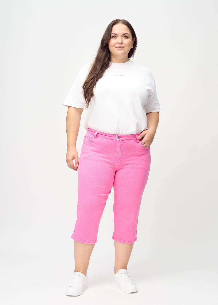 Helbild av en plus size-modell i ljusrosa regular capris.