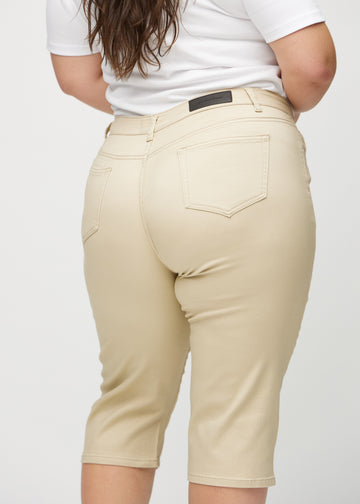 Beige regular capris sedda bakifrån i närbild på en plus-size-modell för att visa detaljer.