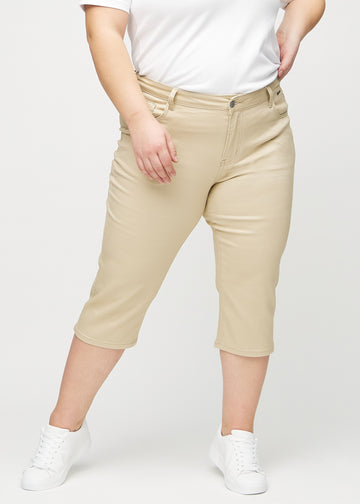 Beige regular capris, modellnamn Gazelles, som sitter rakt längs benet och slutar precis under knät på en plus-size-modell, framifrån.