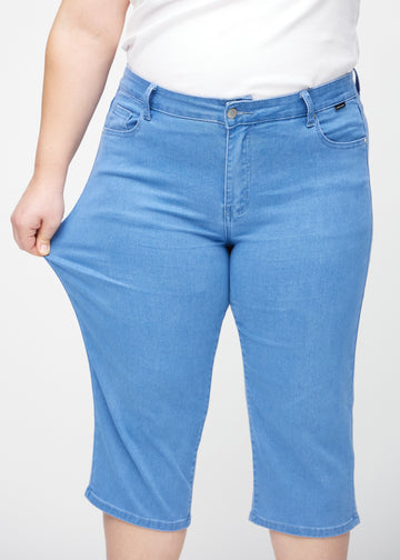 Plus-size-modellen sträcker caprisen vid låret för att visa stretch.