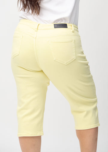 Ljusgula regular capris sedda bakifrån i närbild på en plus size-modell för att visa detaljer.