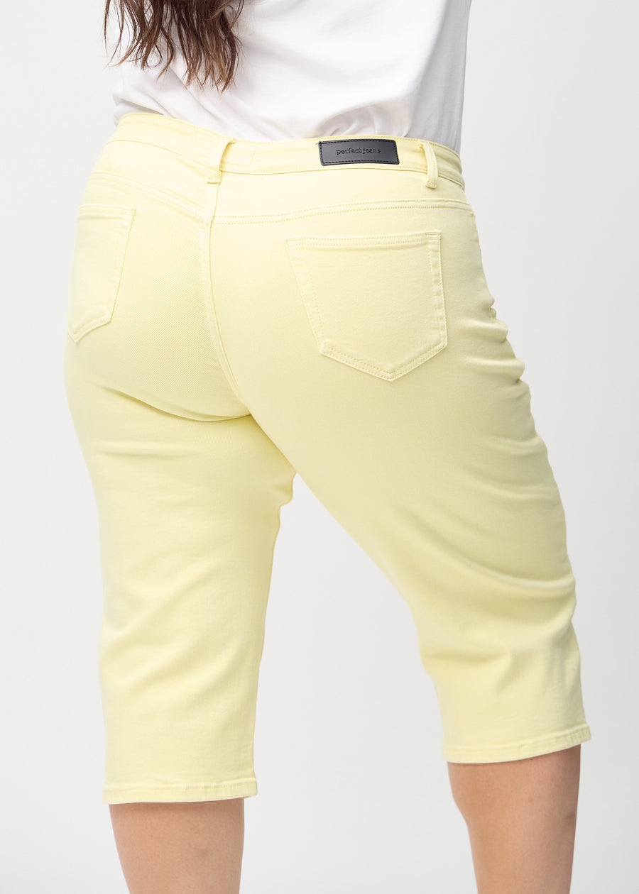 Ljusgula regular capris sedda bakifrån i närbild på en plus size-modell för att visa detaljer.