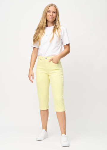 Helbild av modell i ljusgula skinny capris.

