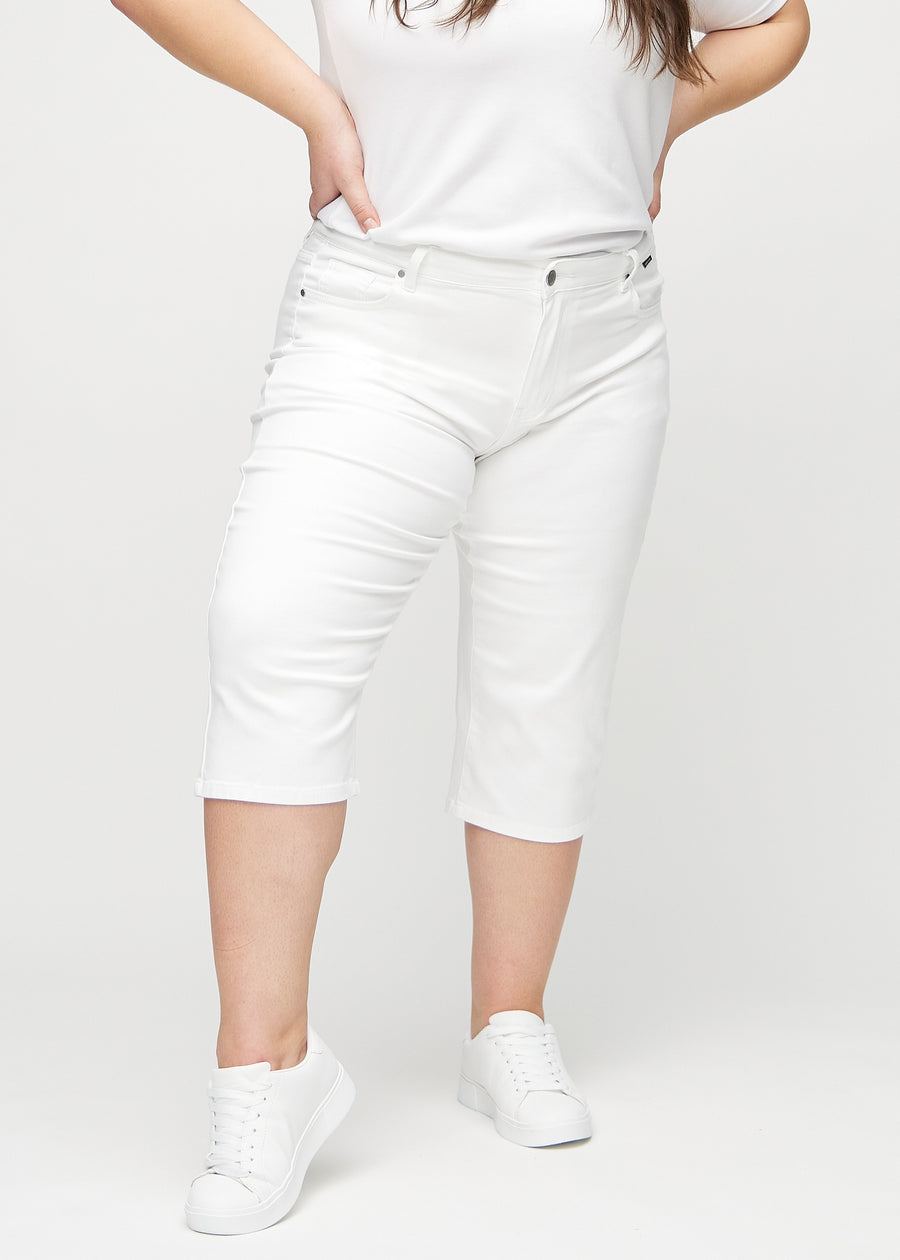 Vita regular capris, modellnamn Marguerites, som sitter rakt längs benet och slutar precis under knät på en plus size-modell, sedda framifrån.