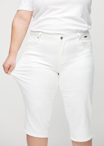Plus size-modellen sträcker caprisen vid låret för att visa stretch.