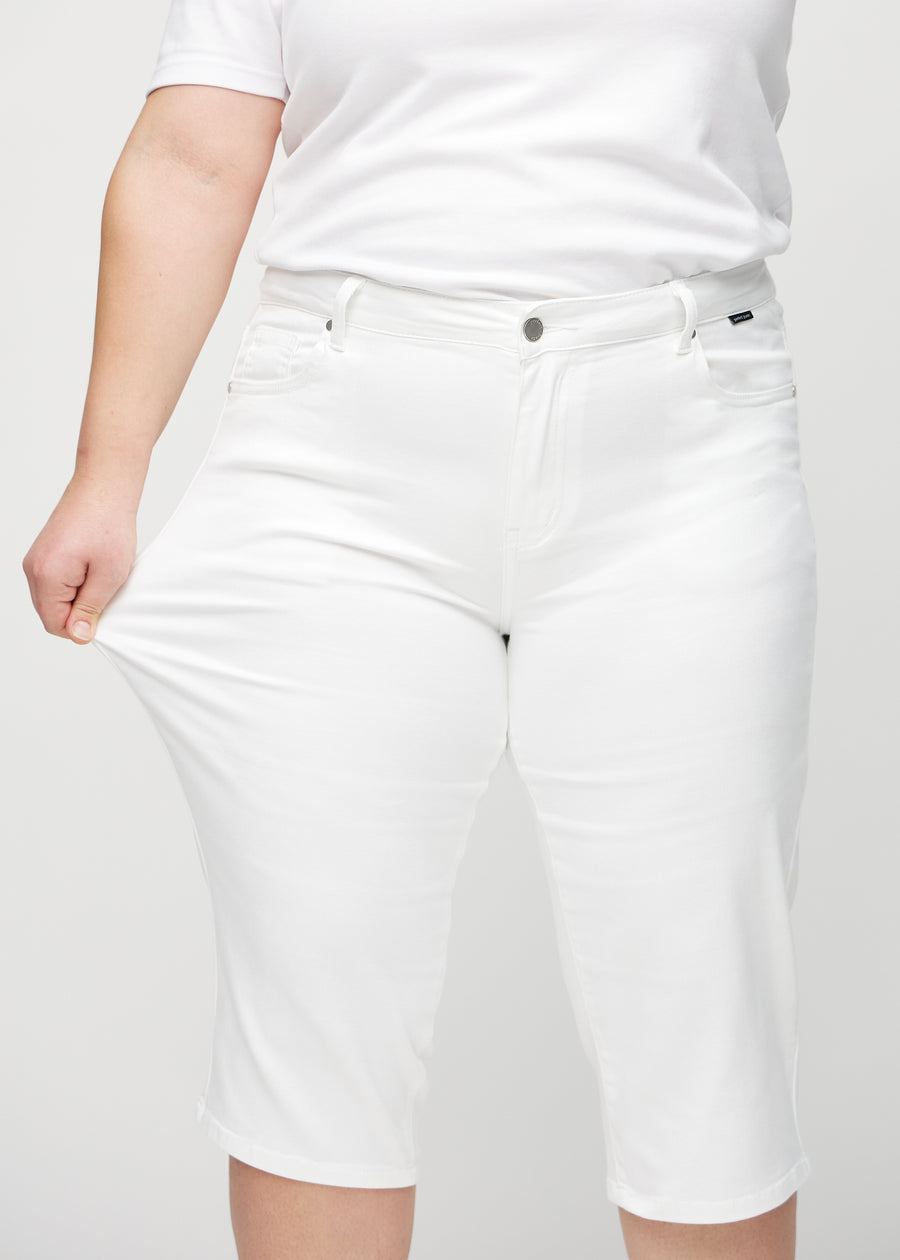 Plus size-modellen sträcker caprisen vid låret för att visa stretch.