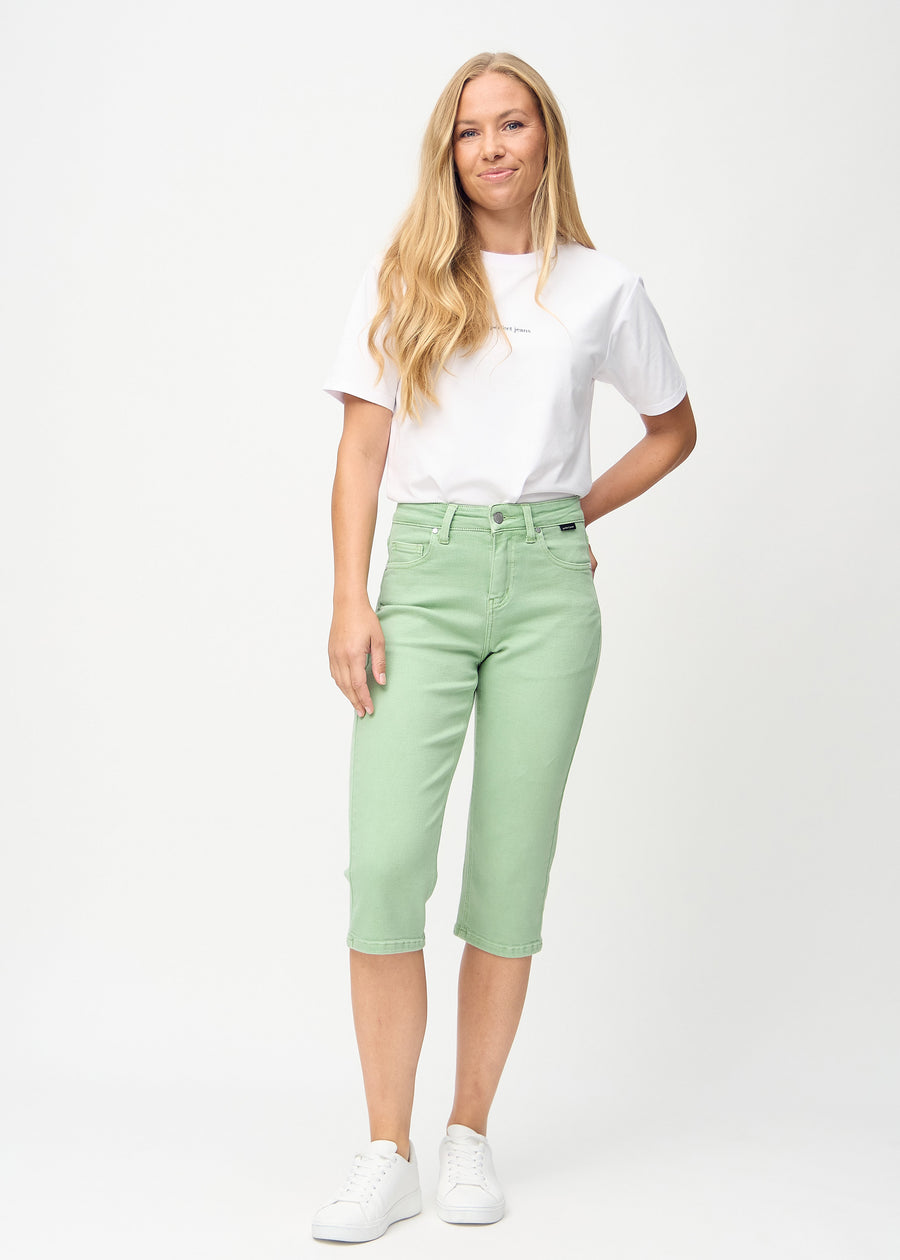 Helbild av modell i ljusgröna regular capris.