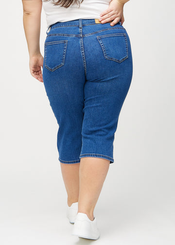 Mörk denim regular capris sett bakifrån på en plus size-modell, så att man kan se hela produkten.